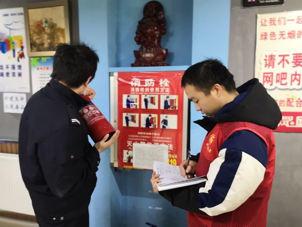 志愿者对网吧进行灭火器检查.jpg