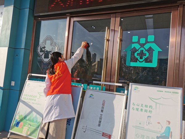 志愿者擦拭玻璃上胶布痕迹.jpg