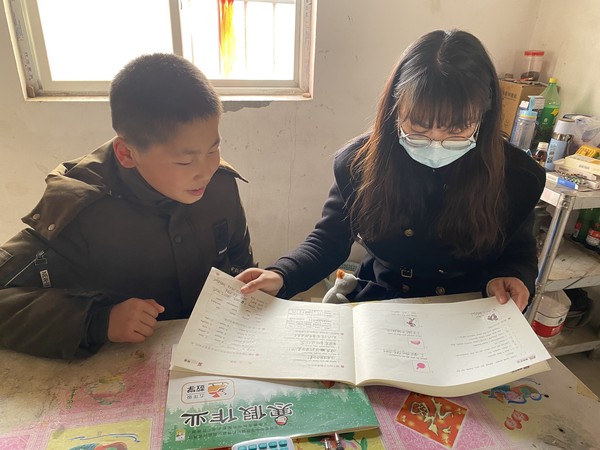 教师走访入户为留守儿童辅导作业.jpg