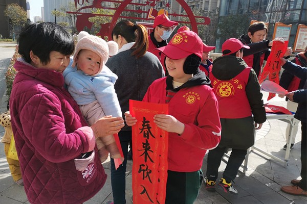 学生志愿者向居民赠送春联.jpg