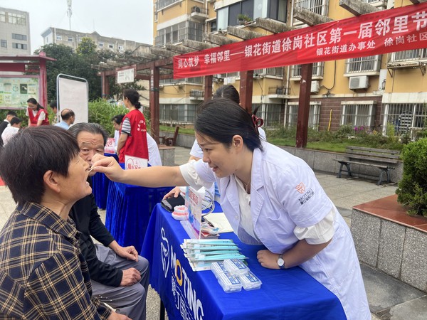 徐岗社区“同心筑梦 幸福邻里”邻里节活动中志愿者为居民提供口腔健康检查.jpg
